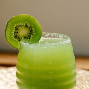 Glass of NFC kiwifruit juice garnished with a fresh slice